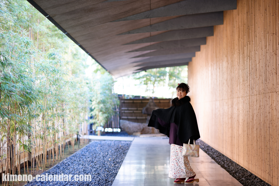 絹の白い着物の上に着物コートを羽織っている女性